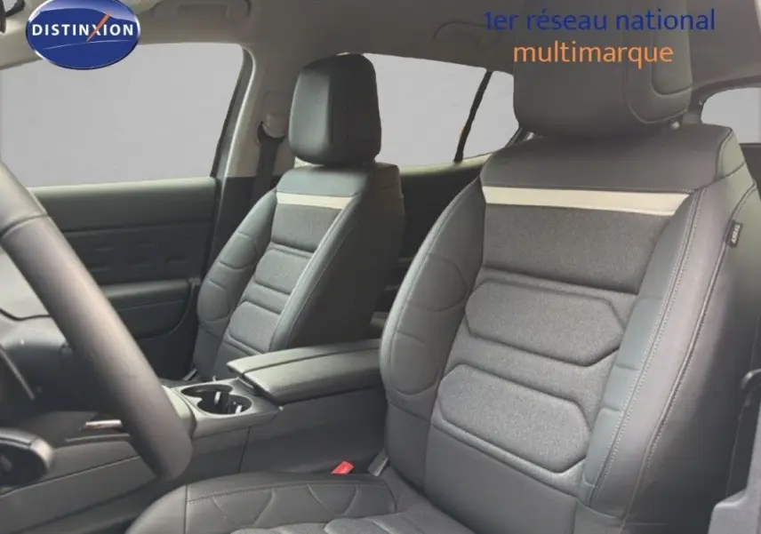 Vue intérieure sur les sièges avant en cuir et tissu gris du Citroën C5 Aircross Hybrid 2025, avec accoudoir central.