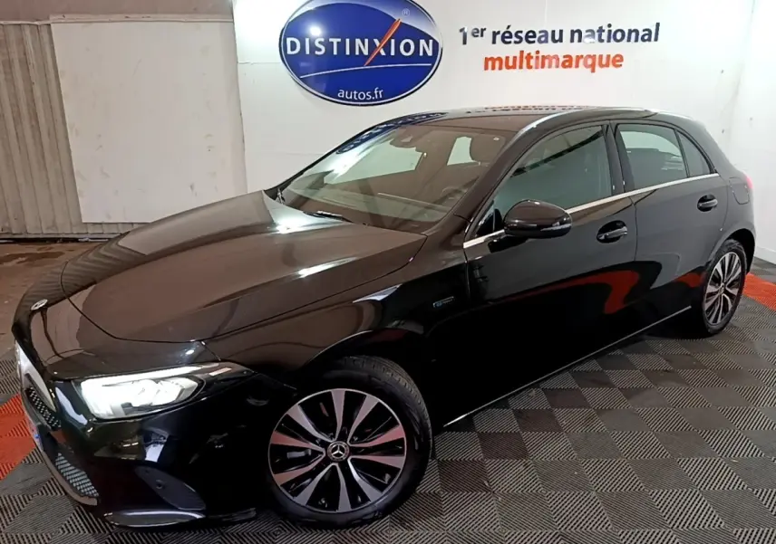 Vue 3/4 avant droite d'une Mercedes Classe A noire brillante dans un showroom avec éclairage intérieur.