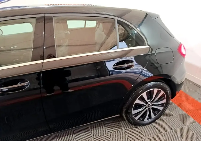 Vue latérale droite d'une Mercedes Classe A 250 e Business Line noire, mettant en valeur la porte arrière et la roue arrière.