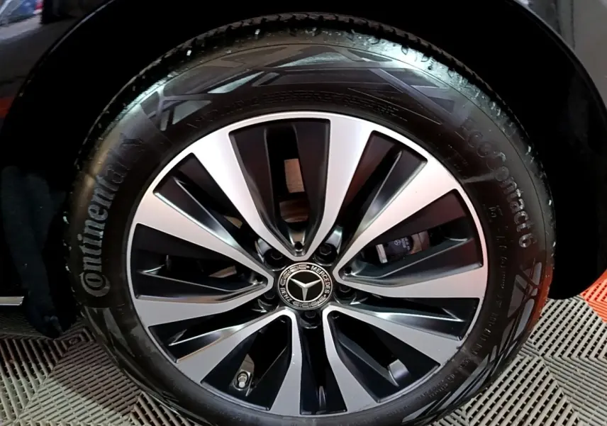 Gros plan sur la jante alliage bicolore et pneu Continental d'une Mercedes Classe A noire, version A 250 e Business Line.