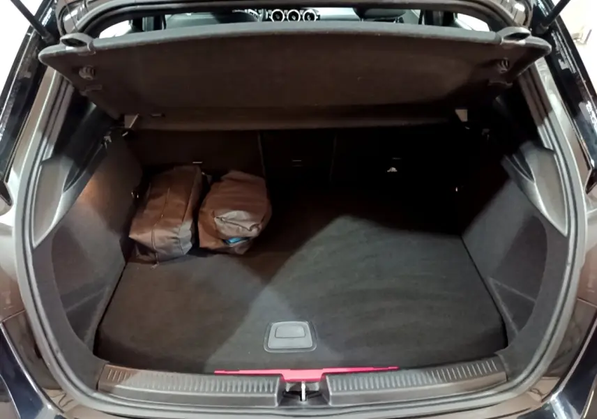 Coffre ouvert vu de l'arrière d'une Mercedes Classe A 250 e Business Line noire avec deux sacs à l'intérieur.