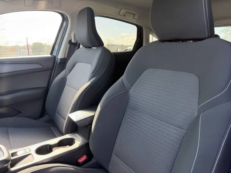 Intérieur du Renault Arkana 2025 montrant les sièges avant en tissu gris avec surpiqûres blanches, vue côté droit.