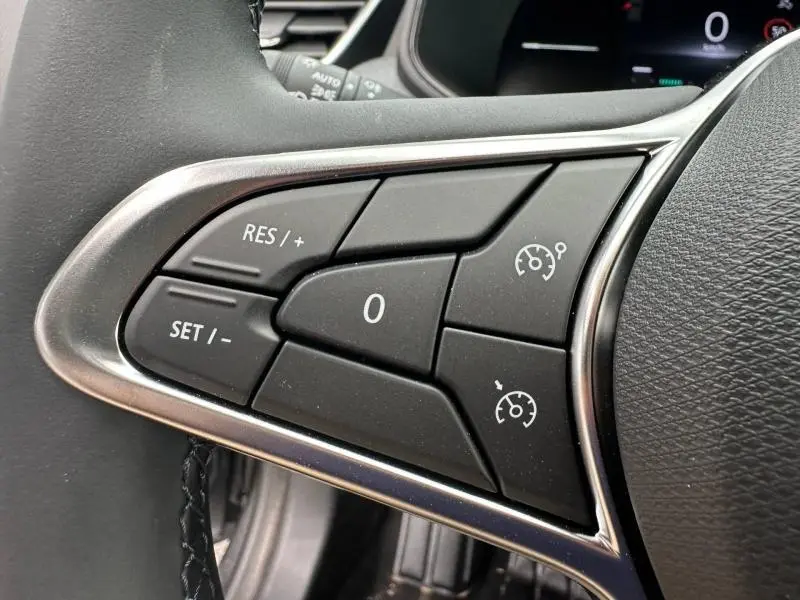 Gros plan sur les commandes du régulateur de vitesse au volant d'une Renault Clio gris Rafale, version 2025.