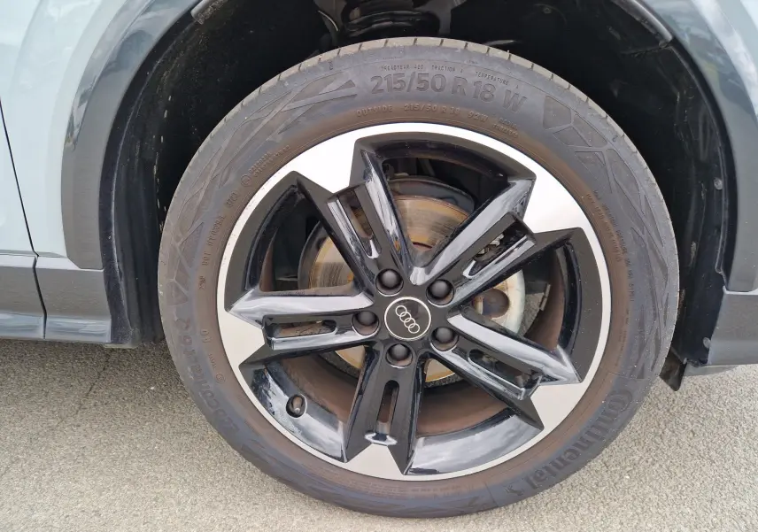 Gros plan sur la jante Audi Sport 18'' noire et argentée du côté avant gauche du Q2 gris flèche.