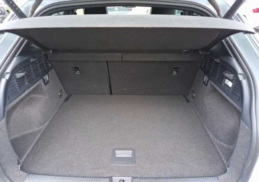 Coffre ouvert vu de l'arrière d'un Audi Q2 35 TFSI 2023 gris flèche, montrant un espace de chargement propre et spacieux.