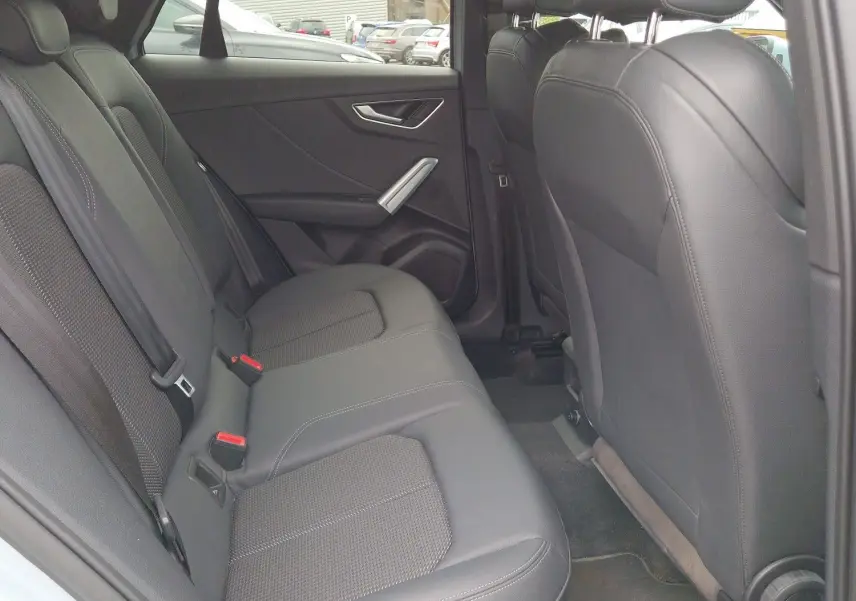 Vue intérieure côté gauche des sièges arrière en cuir noir de l'Audi Q2 35 TFSI 2023 finition S line.