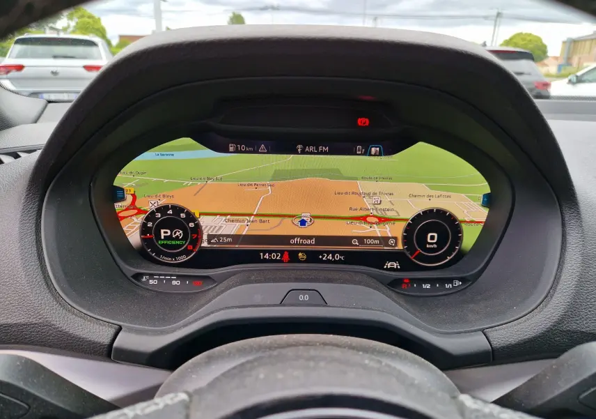 Vue rapprochée du tableau de bord numérique Audi virtual cockpit du Q2 35 TFSI 2023 avec navigation affichée.