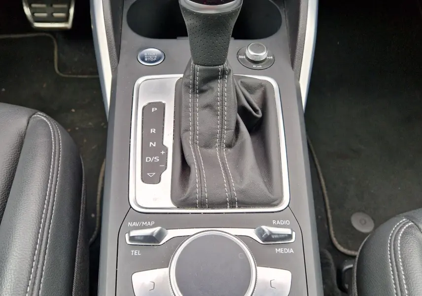 Vue rapprochée de la console centrale avec levier de vitesse automatique et commandes MMI de l’Audi Q2 35 TFSI 2023 finition S line.
