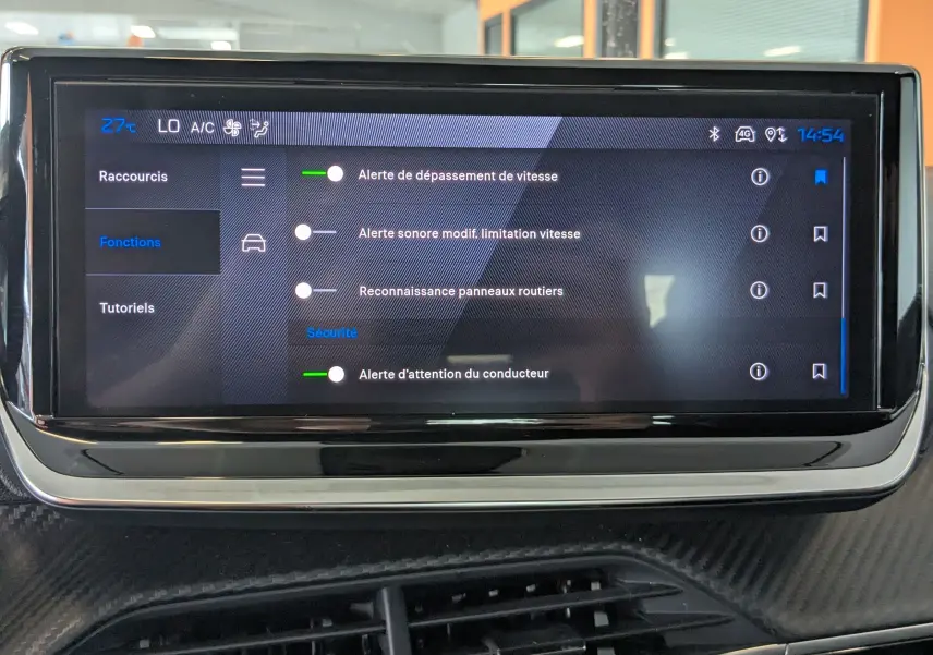 Écran tactile central affichant les options de sécurité du système d’alerte dans un Peugeot 208 Hybrid 145 gris Selenium.