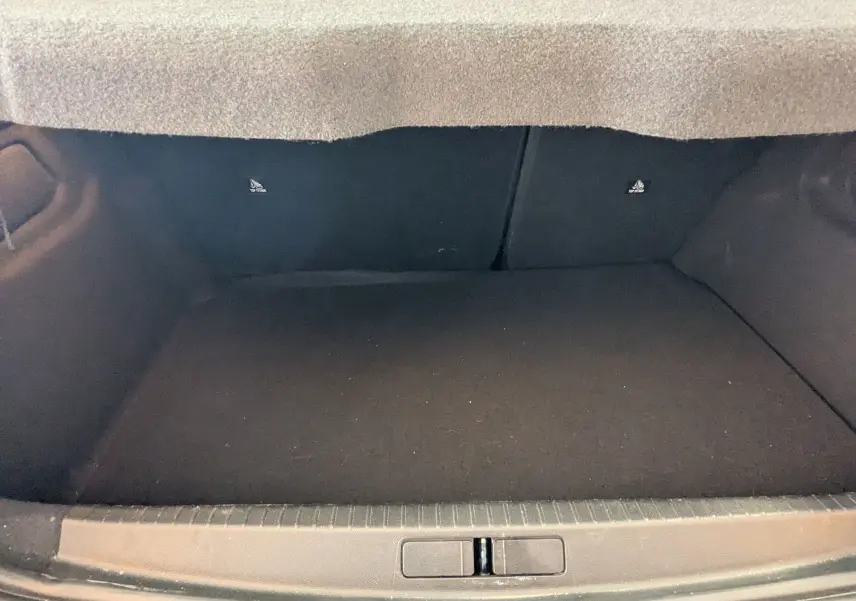 Coffre vide vu de face du Peugeot 208 Hybrid 145 e-DCS6 GT, intérieur noir, sans chargement visible.