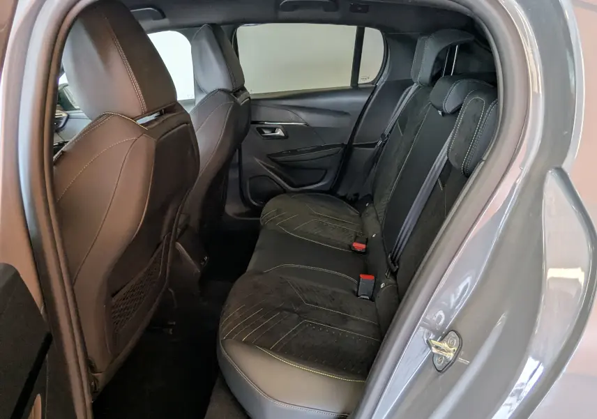 Vue intérieure côté droit des sièges arrière en Alcantara noir avec surpiqûres vertes du Peugeot 208 Hybrid 145 gris selenium.