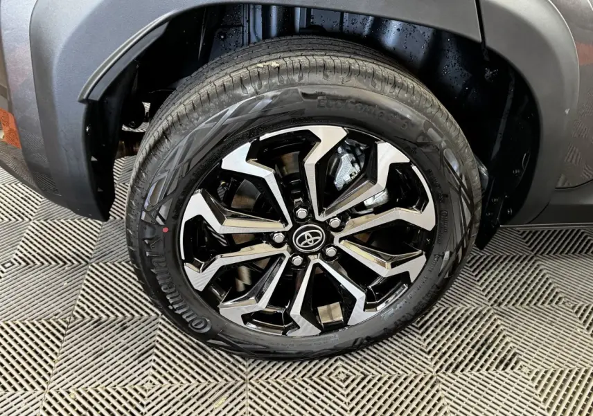 Gros plan sur la roue avant droite de la Toyota Yaris Cross gris foncé, jante alliage noire et argentée au design moderne.