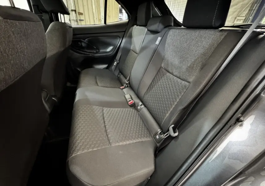 Vue intérieure côté droit sur la banquette arrière gris foncé de la Toyota Yaris Cross 1.5 Hybrid 130h Design Auto 2026.