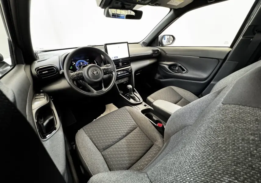 Vue intérieure côté conducteur de la Toyota Yaris Cross 2026, volant cuir multifonctions et écran tactile central.