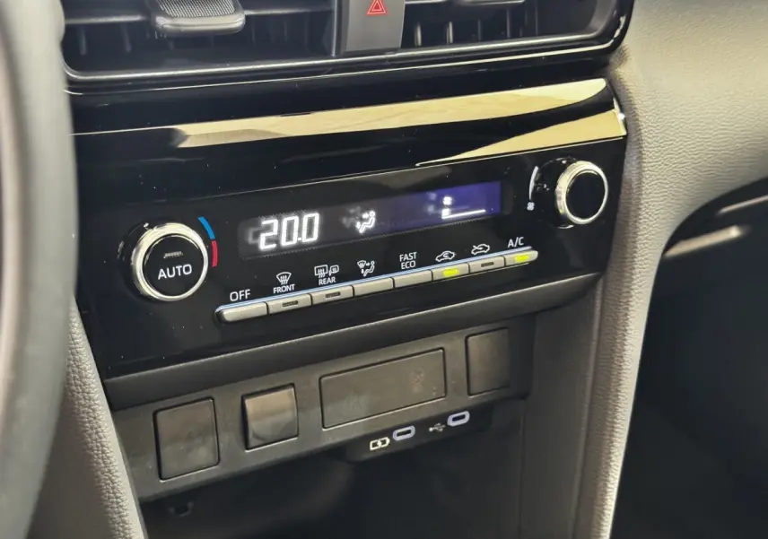 Vue rapprochée de la console centrale noire de la Toyota Yaris Cross 2026 avec commandes climatisation et ports USB visibles.