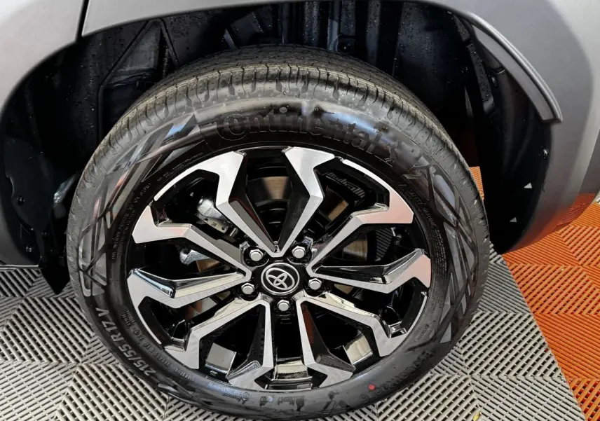 Gros plan sur la roue avant droite de la Toyota Yaris Cross 2026 gris foncé avec jante alliage noire et argentée.