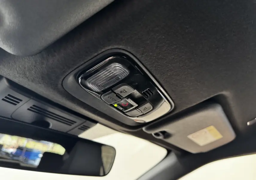 Plafonnier intérieur avec commandes d’éclairage et assistance d’urgence, vue depuis l’habitacle d’une Toyota Yaris Cross gris foncé.