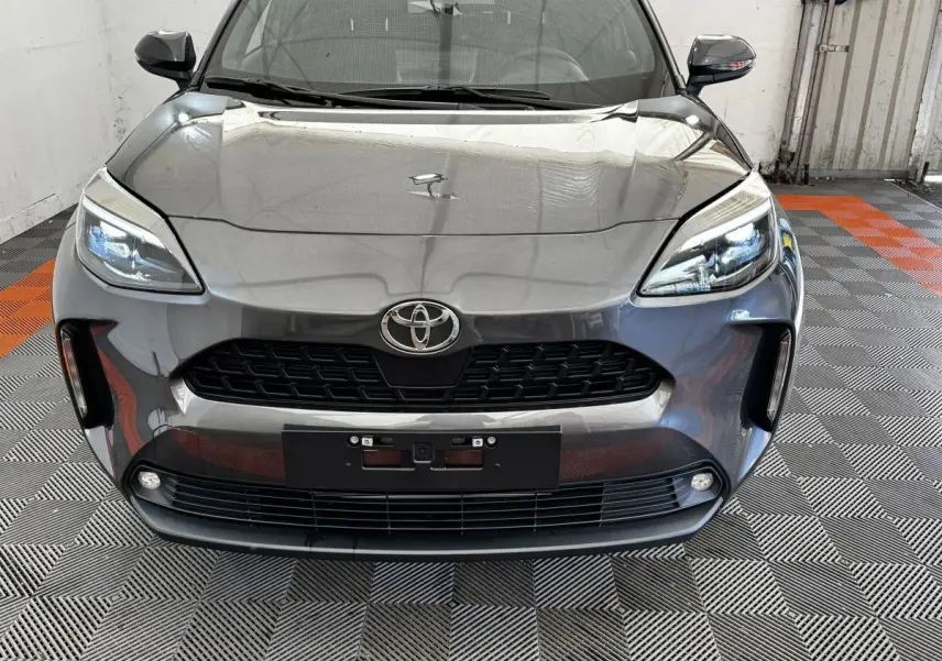 Vue frontale d'une Toyota Yaris Cross 2026 gris foncé avec phares LED et calandre noire distinctive.