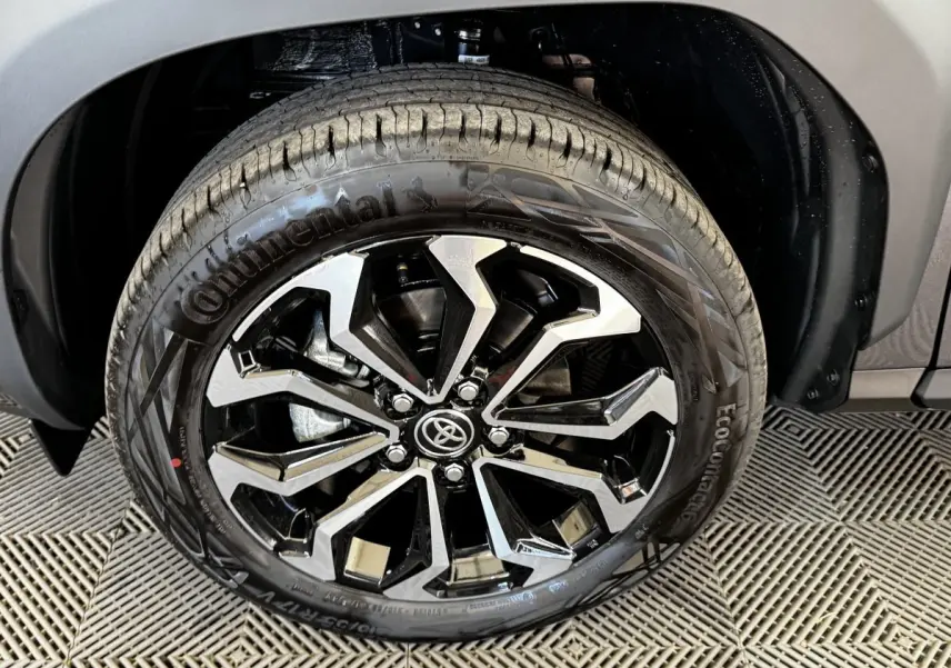 Gros plan sur la roue avant droite du Toyota Yaris Cross gris foncé, jante alliage noire et argentée design moderne.