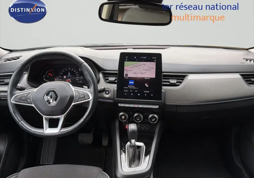 Vue intérieure frontale du tableau de bord gris et noir du Renault Arkana 2022 avec écran tactile central et volant cuir.