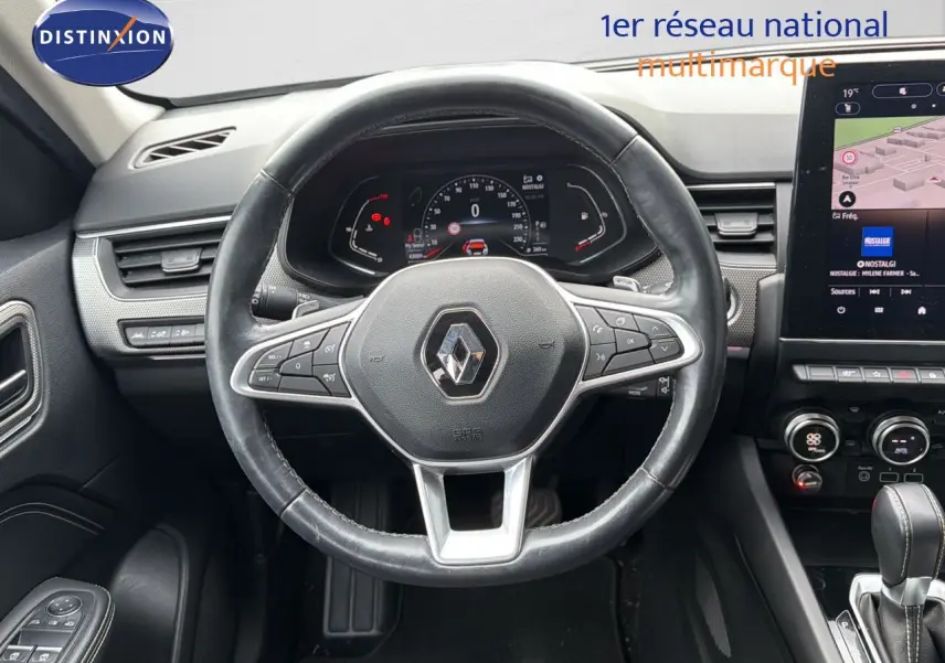 Vue intérieure centrée sur le volant cuir noir et le tableau de bord numérique du Renault Arkana gris 2022.