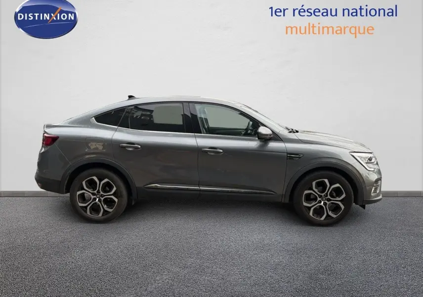 Profil droit d'un Renault Arkana gris 2022 avec jantes alliage bi-ton et lignes fluides de SUV coupé.