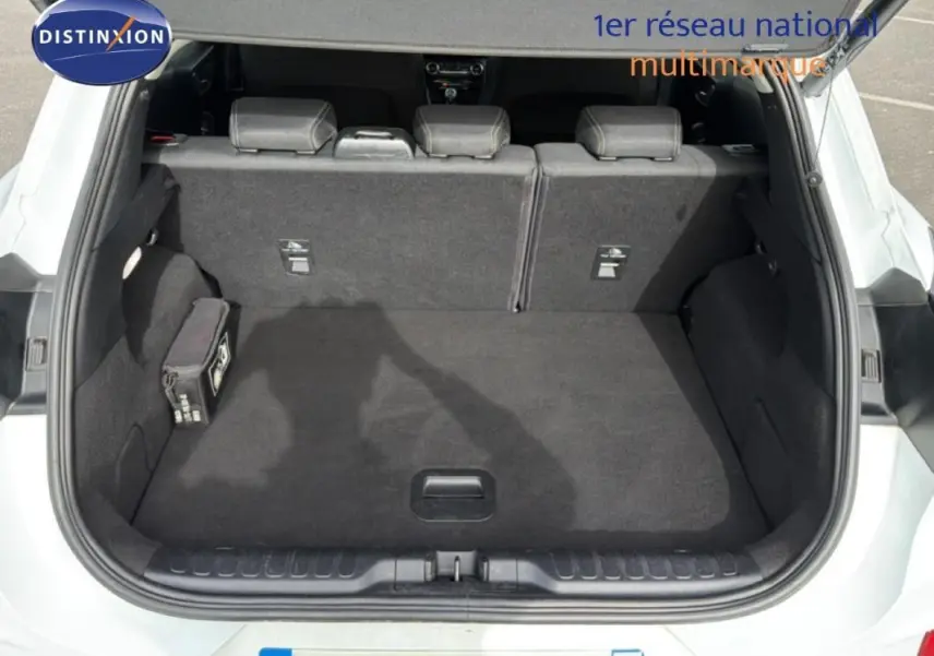 Coffre ouvert vu de l'arrière d'un Ford Puma blanc 2020, montrant l'espace de chargement et les sièges arrière rabattables.