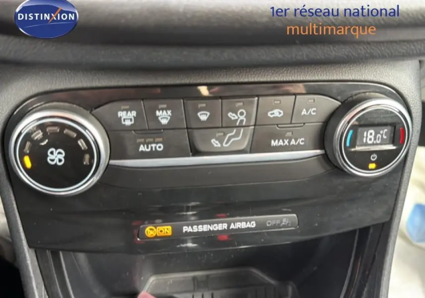 Gros plan sur la console de climatisation noire du Ford Puma blanc, affichant 18°C et commandes tactiles.