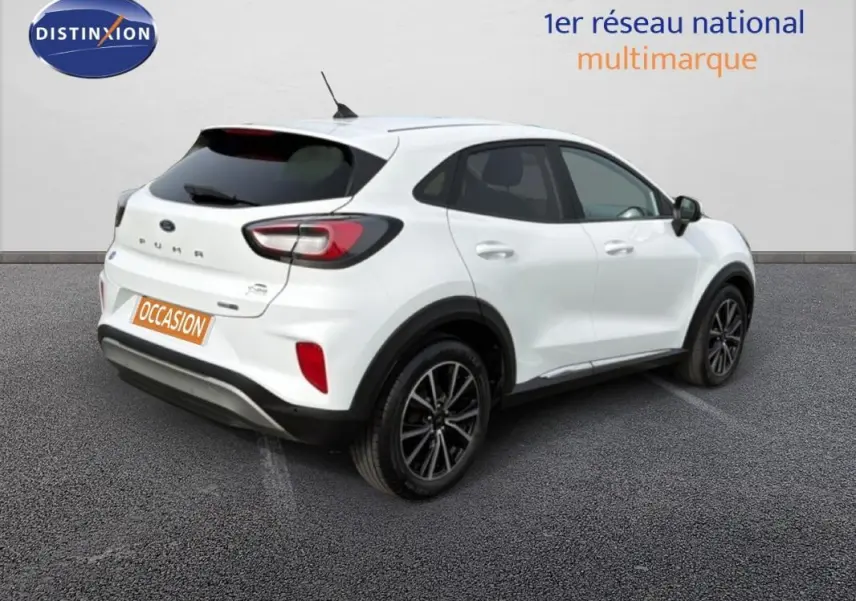 Vue 3/4 arrière droite d’un Ford Puma blanc avec jantes alliage noires et vitres surteintées.