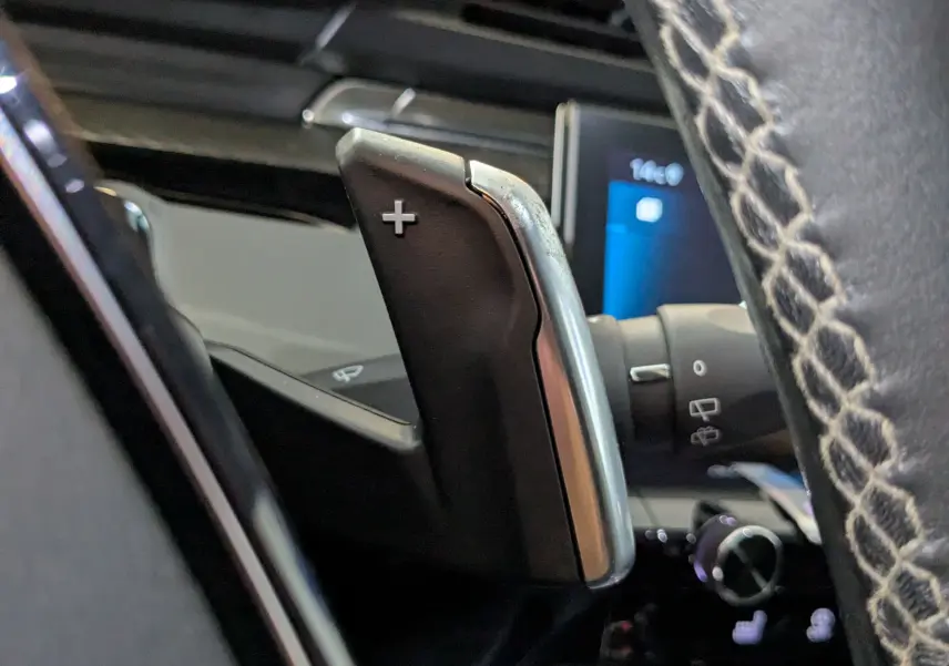 Gros plan sur la palette de changement de vitesse "+" côté droit du volant en cuir perforé du Peugeot 508 SW gris.