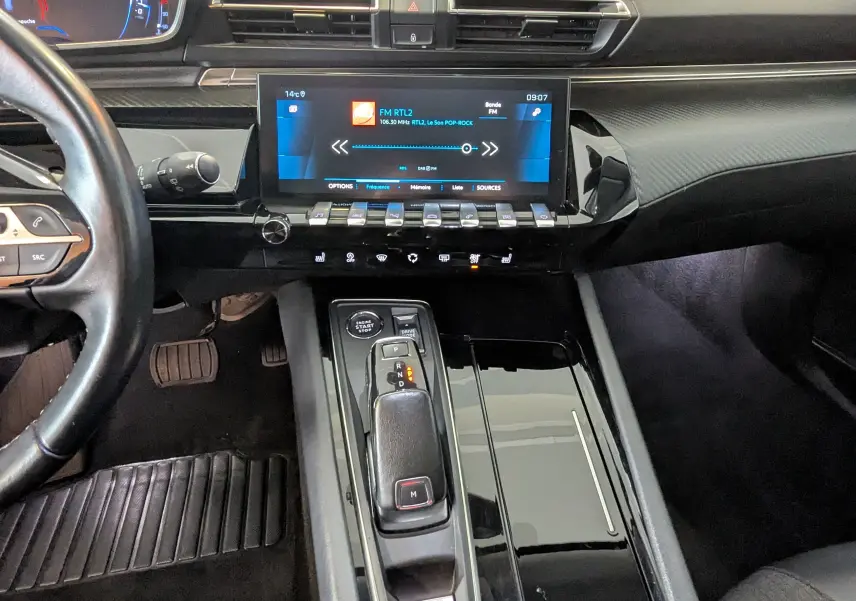 Vue intérieure du tableau de bord et console centrale noire de la Peugeot 508 SW 1.5 dCi BlueHDi 2021 avec écran tactile et levier de boîte automatique.