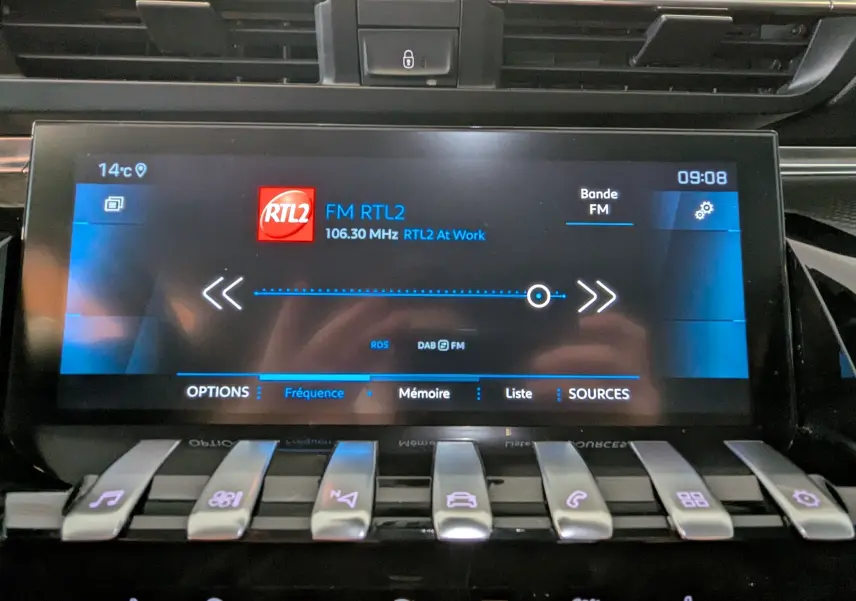 Écran tactile central de la Peugeot 508 SW gris, affichant la radio FM RTL2 à 09:08 avec commandes piano en dessous.