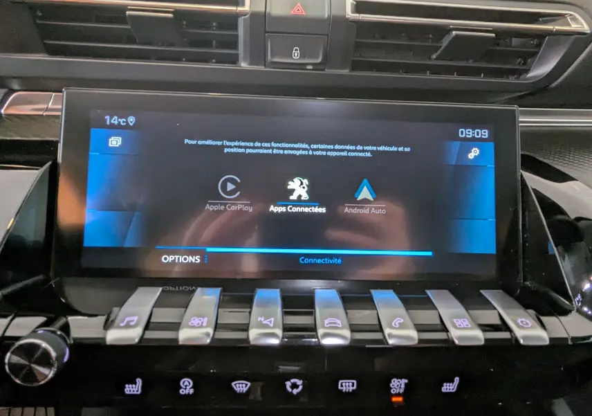 Vue rapprochée de l’écran tactile central et des commandes piano de la Peugeot 508 SW gris 2021, intérieur moderne.