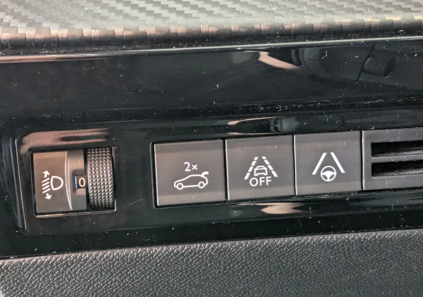 Gros plan sur les boutons de commande intérieurs noirs du tableau de bord d'une Peugeot 508 SW gris 2021.