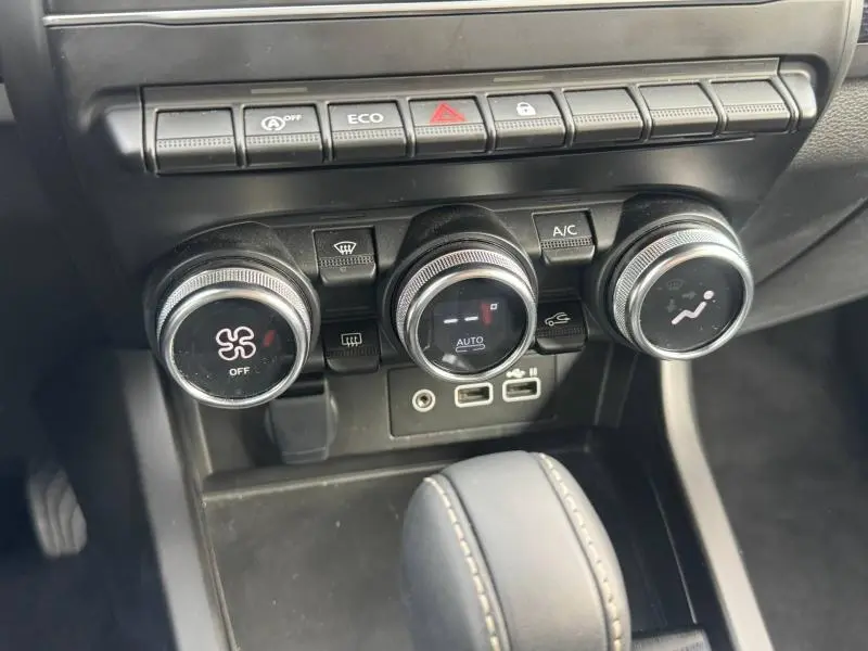 Vue rapprochée du tableau de bord du Renault Arkana 2025 montrant les commandes de climatisation et les ports USB.