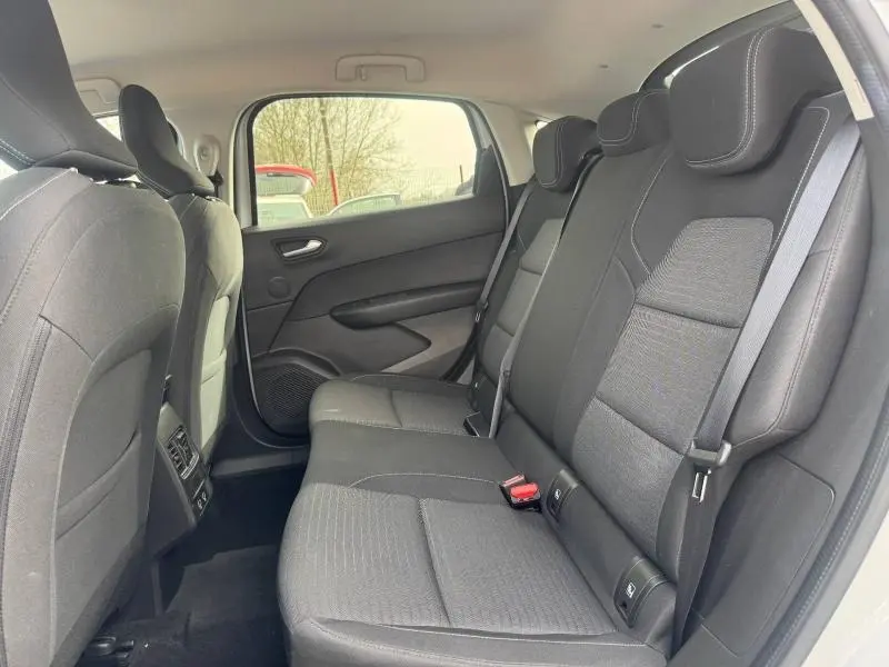 Vue intérieure arrière côté droit du Renault Arkana blanc 2025, montrant les sièges arrière en tissu noir avec appuie-têtes.