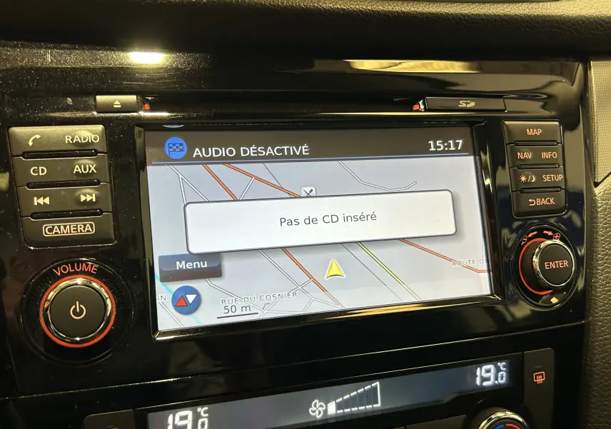 Gros plan sur l’écran tactile du système de navigation du Nissan Qashqai blanc, affichant une carte et l’alerte "Pas de CD inséré".