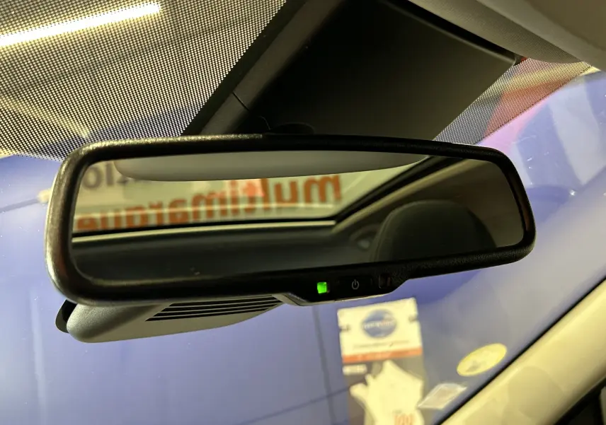 Rétroviseur intérieur du Nissan Qashqai blanc, vue rapprochée avec toit panoramique visible en reflet.