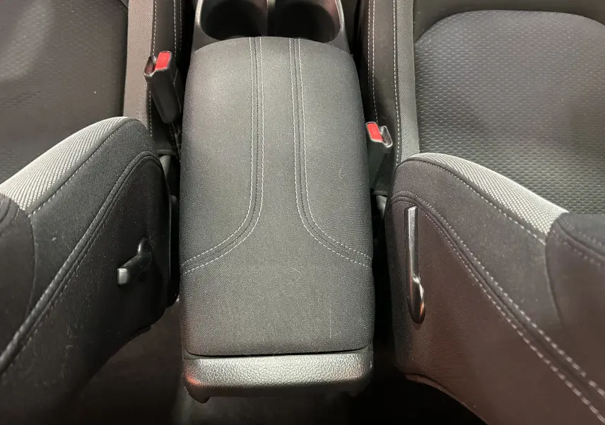 Vue rapprochée de l'accoudoir central en tissu noir entre les sièges avant du Nissan Qashqai 2018.