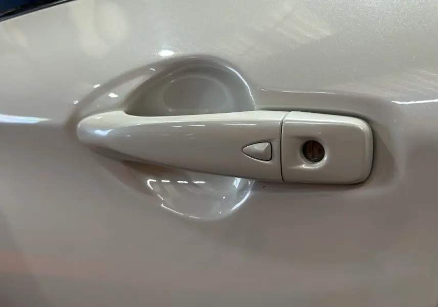 Poignée de porte côté gauche blanche du Nissan Qashqai 1.6 dCi 130 N-Connecta 2018 vue en gros plan.