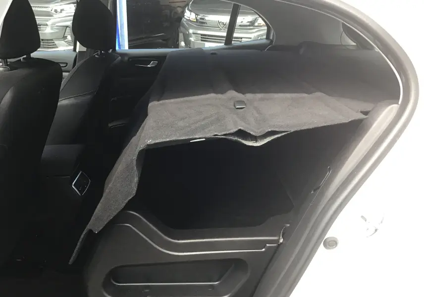Vue intérieure côté droit du coffre d'une Renault Mégane IV Société blanche, avec cache-bagages déployé.