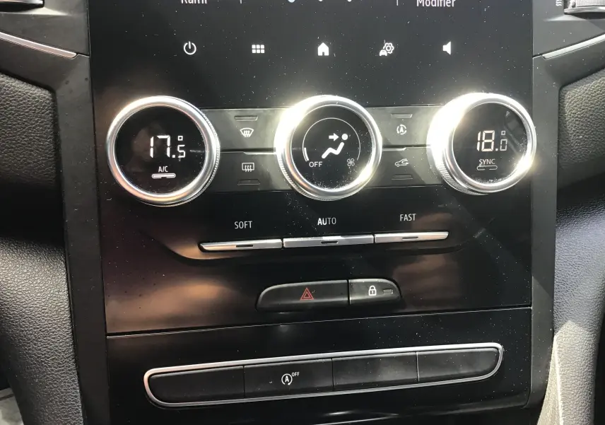 Détail du tableau de bord de la Renault Megane IV Société 2021, montrant les commandes de climatisation digitales et boutons centraux.