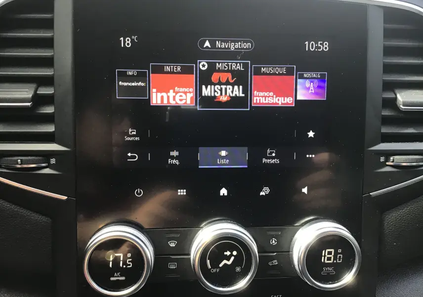 Vue rapprochée de l’écran tactile central et des commandes de climatisation du Renault Mégane IV Société blanc de 2021.