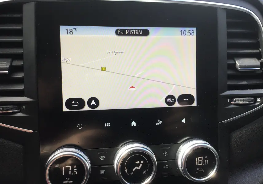 Gros plan sur l’écran tactile central et la console de climatisation du Renault Mégane IV Société blanc, affichant la navigation GPS.