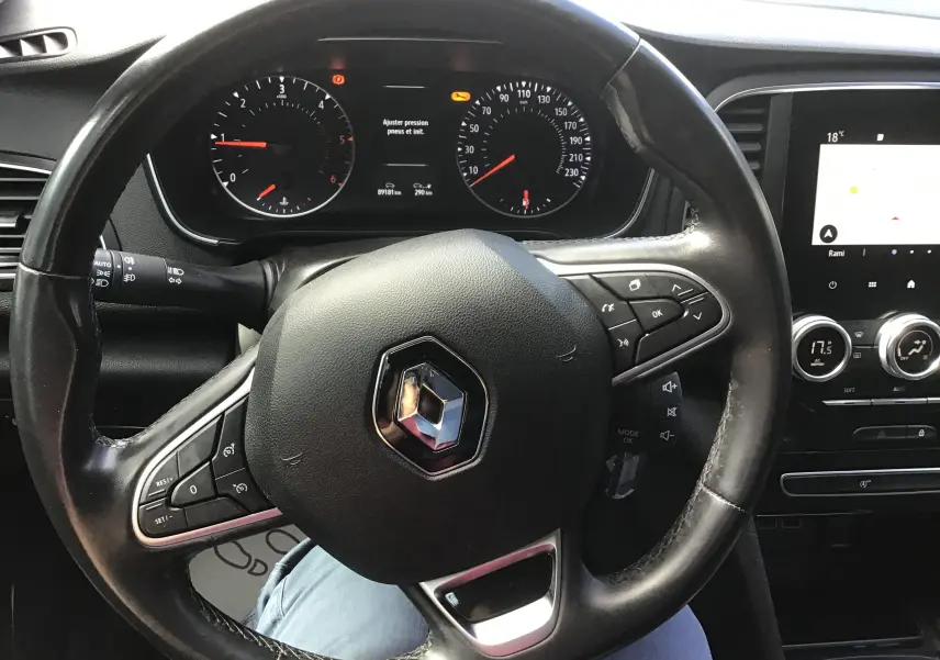 Vue rapprochée du volant noir de la Renault Mégane IV Société 2021 avec tableau de bord et écran tactile visibles.