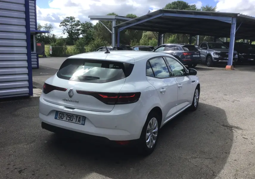 Vue 3/4 arrière droite d'une Renault Mégane IV Société blanche, avec feux arrière allongés et plaque d'immatriculation française.