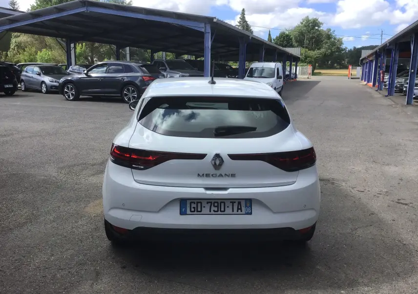 Vue arrière d’une Renault Mégane IV Société blanche, avec feux arrière allongés et plaque d’immatriculation française visible.