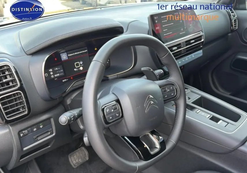 Vue intérieure du poste de conduite du Citroën C5 Aircross 2025, volant cuir noir et tableau de bord numérique.