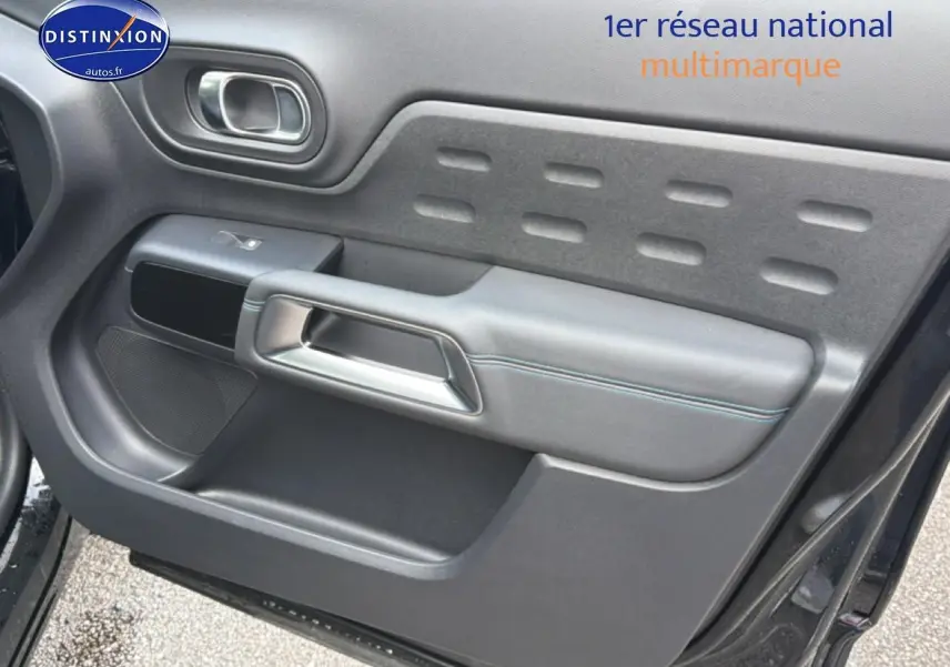Intérieur de la porte avant gauche du Citroën C5 Aircross noir Perla Nera avec poignée argentée et surpiqûres bleues.