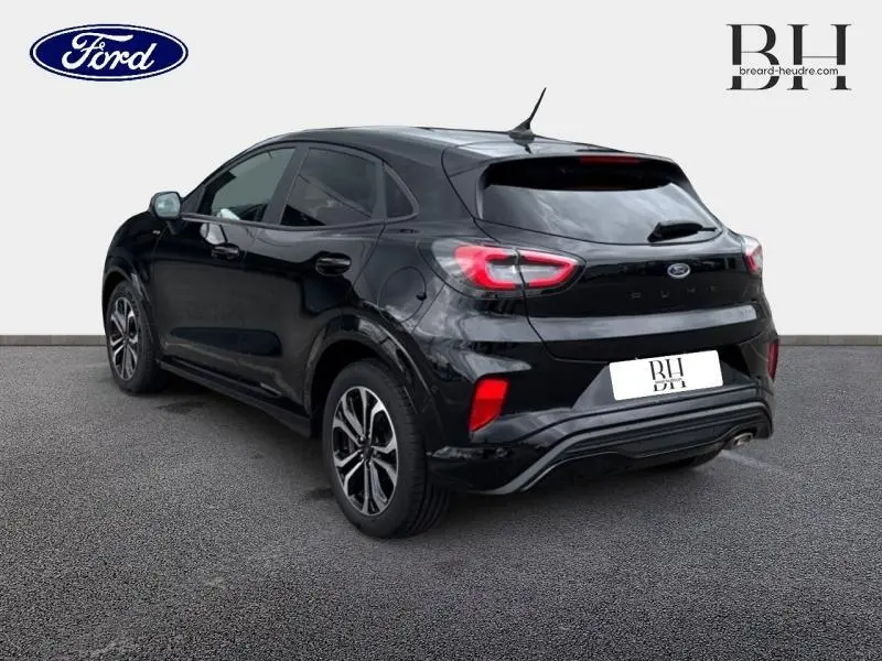 Ford Puma 2023 noir Agate métallisé vu en 3/4 arrière droit avec vitres arrière surteintées et feux LED distinctifs.